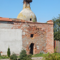 Башня монастырской стены с гнездом аиста и сохранившейся старой кирпичной кладкой.