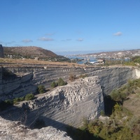 Вид с восточной стороны Монастырской скалы на бывший карьер и остатки башен крепости Каламита. За ними - Зелёная горка и Инкерманская бухта