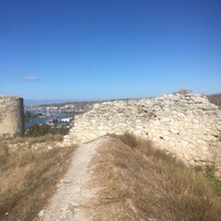 Остатки полукруглой башни и стены крепости Каламита на вершине юго-западной части Монастырской скалы на фоне Инкерманской бухты