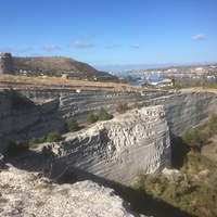 На юго-восточной стороне Монастырской скалы. Вид на боковой срез карьера каменоломни - северо-восточную стену скалы, остатки башен крепости Каламита, Зелёную горку и Инкерманскую бухту