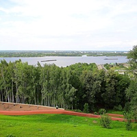 Вид с Верхне-Волжской набережной на аллеи, уличный тренажер и спортивные снаряды в Александровском саду, акваторию Волги и прибрежную зону.