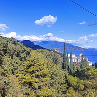 Вид с канатной дороги санатория "Горный" в п.г.т. Курпаты на южный склон Ай-Петринского массива Черноморскую акваторию и побережье,  корпус "Дружба" («летающая тарелка») комплекса «Курпаты» Управления делами Президента РФ.