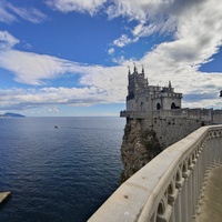 Вид со смотровой площадки во внутреннем дворе замкового комплекса "Ласточкино гнездо" на вершине Аврориной скалы на псевдоготический замок и окружающую акваторию.