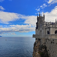Вид со смотровой площадки во внутреннем дворе замкового комплекса "Ласточкино гнездо" на вершине Аврориной скалы на псевдоготический замок и окружающую акваторию.