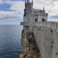 Вид со смотровой площадки во внутреннем дворе замкового комплекса "Ласточкино гнездо" на вершине Аврориной скалы на псевдоготический замок и окружающую акваторию.