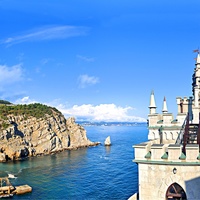 Вид с верхней смотр. площадки барбакана на псевдоготический замок "Ласточкино гнездо" и на побережье мыса Ай-Тодор с действующей и строящейся инфраструктурой и его восточный (Лимен-Бурун) отрог с отдельной маленькой скалой Парус.