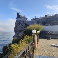 Вид с площадки на склоне Аврориной скалы (среднего отрога Монастыр-Бурун) мыса Ай-Тодор на псевдоготический замок "Ласточкино гнездо" и балюстраду смотровой площадки внутреннего двора замкового комплекса.