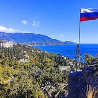 На вершине горы Урьянда (Крестовая). Флаг РФ, установленный в 2014г. Вид на акваторию, побережье с застройкой посёлка Ореанда. В центре - полуротонда на Царской тропе. Далее - застройка Ливадии и Ялты на южном склоне Главной гряды Крымских гор.