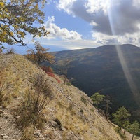 Скалистый обрыв южного склона Ялтинской яйлы вдоль экологического маршрута "Штангеевская тропа" около утёса Ставри-Кая на территории Ялтинского горно-лесного заповедника. Справа - гора Могаби.
