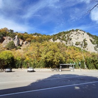 Автостоянка перед храмовым комплексом Архистратига Божия Михаила на Севастопольском шоссе над посёлком Ореанда. Выше - ребро склона горы Ай-Никола с Крестом и Распятием на навершие выступа скалы.