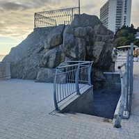 Скала с гротом — изюминка пляжа санатория "Ай-Петри" в Мисхоре. Огромный валун с отверстием, через которое можно попасть внутрь скалы и выйти на пляж. На вершине скалы находится смотровая площадка.