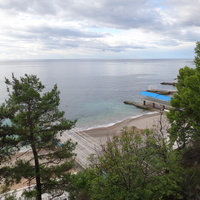 Парк "Дюльбер". Разбит в к. XIX в. Инициатор - велик. князь П. Н. Романов. Проект дворц.-парк. ансамбля с учётом эскизов Романова разраб. ялт. арх. Н. П. Краснов, высажен с участ.  крым. садовода Л. Кремера. Вид на пляж и Черноморскую акваторию.