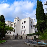 Дворц.-парк. ансамбль "Дюльбер". Построен с 1895 по 1897 г. Инициатор - велик. князь П. Н. Романов. Проект всего ансамбля с учётом эскизов Романова разраб. ялт. арх. Н. П. Краснов, парк высажен с участ.  крым. садовода Л. Кремера. Дворец "Дюльбер".