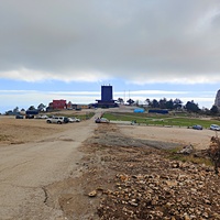 На вершине плато Ай-Петри. В центре - парковка, за ней - верхняя станция канатной дороги, справа - зубцы Ай-Петри.