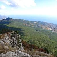 Вид с Кореизской тропы на обрыве перед вершиной Ай-Петринской яйлы на побережье с застройкой Гаспры и акваторию Чёрного моря, слева - зелёный конус г. Могаби, за ним - жилая застройка Ялты.