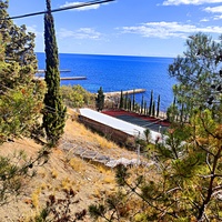 На территории СОСЛ МЭИ "Алушта". Вид с площадки перед жилыми домиками "Стрельбище" на жилой корпус "Бастилия" и теннисный корт за ним.  .