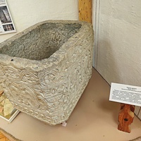 Алуштинский историко-краеведческий музей. Купель резная из нуммулитового известняка, XVв. В композиции перекликаются зоо и орнитоморфный, растительный орнаменты, в центре - изображение двуглавого орла.