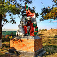 Памятник павшим воинам, справа на заднем плане - братская могила