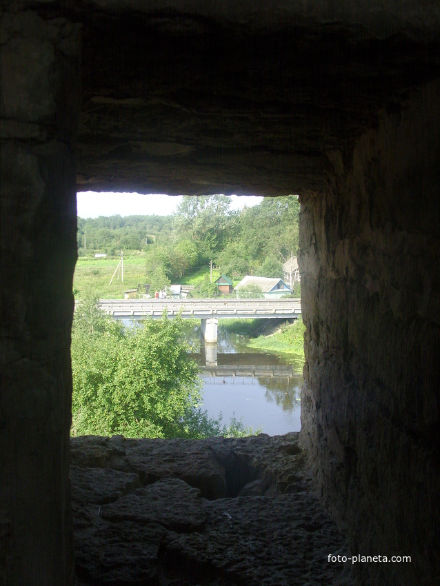 Вид из бойницы крепостных стен на мост через Ладожку