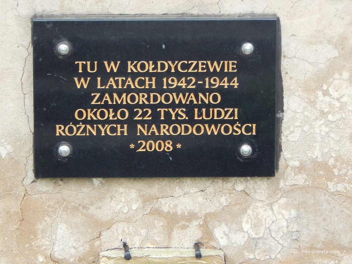 Мемориальная доска с текстом на польском языке.