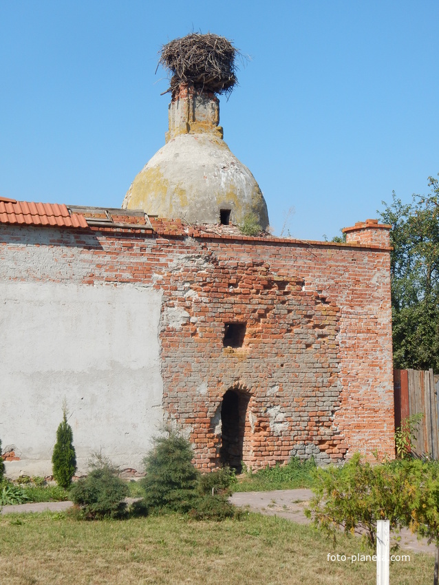 Башня монастырской стены с гнездом аиста и сохранившейся старой кирпичной кладкой.