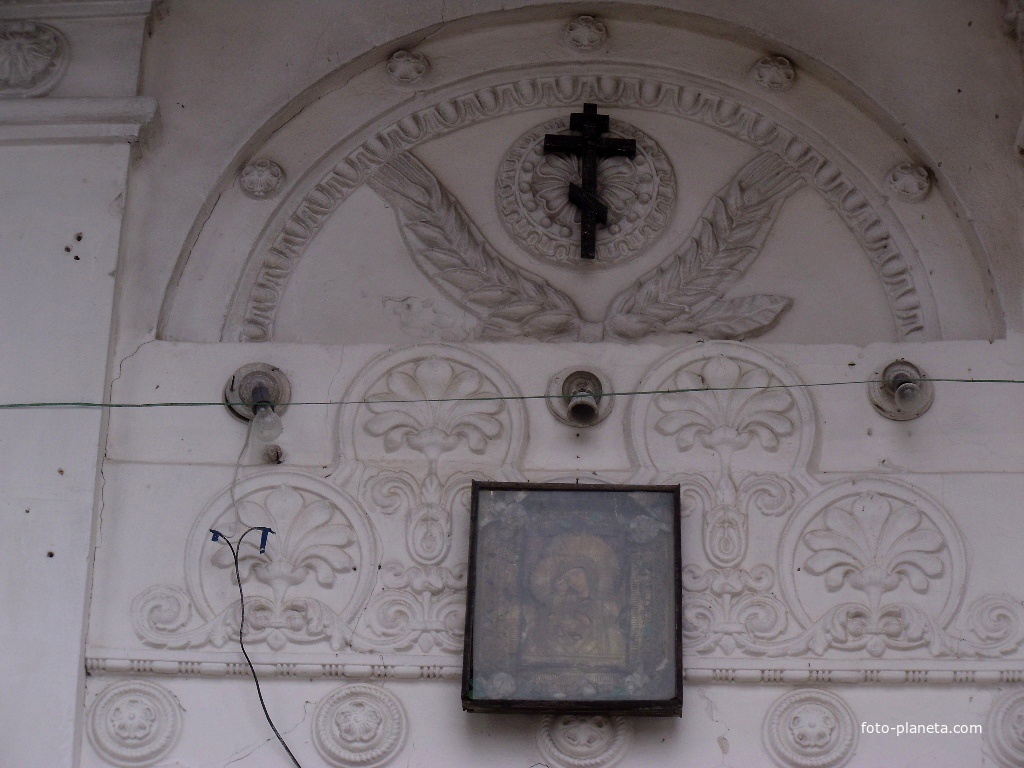 Крест и икона над входом в храм.