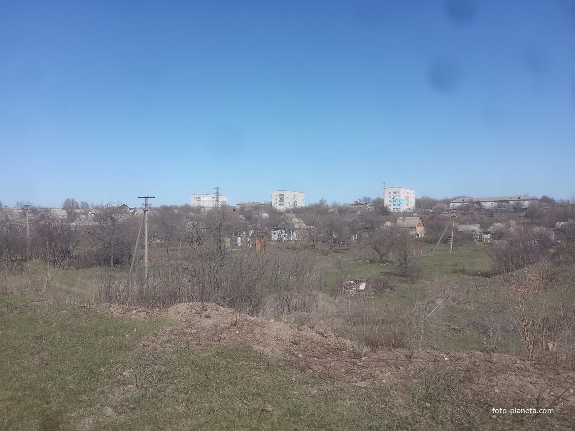 Вид на город с насыпи бывшей узкоколейной железной дороги Синельниковского кирпичного завода в старом карьере.