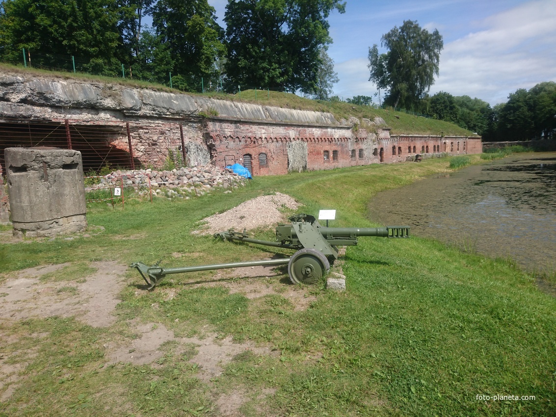 Внешний ров с водой и стена форта №5 с немецким 75-мм противотанковым орудием Pak 40 справа от входа в крепость