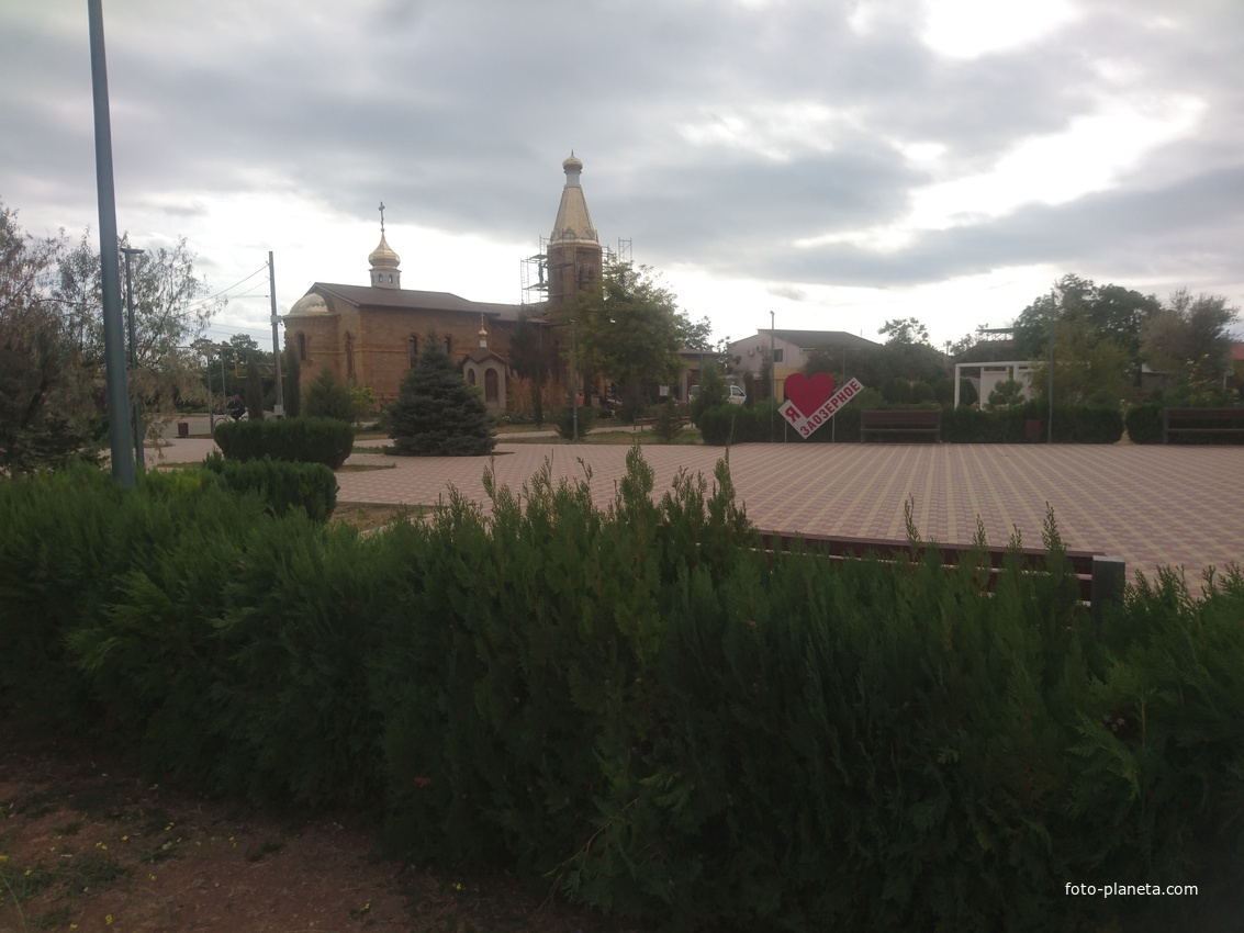 Поселковый сквер со стелой &quot;Я люблю Заозёрное&quot;. За ним храм священномученика Порфирия, епископа Симферопольского и Крымского