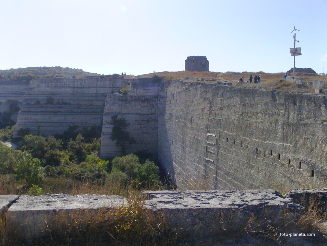 На Монастырской скале. Вид на восточную стену старого карьера каменоломни, панель солнечной батареи и остатки башни  и стены крепости Каламита