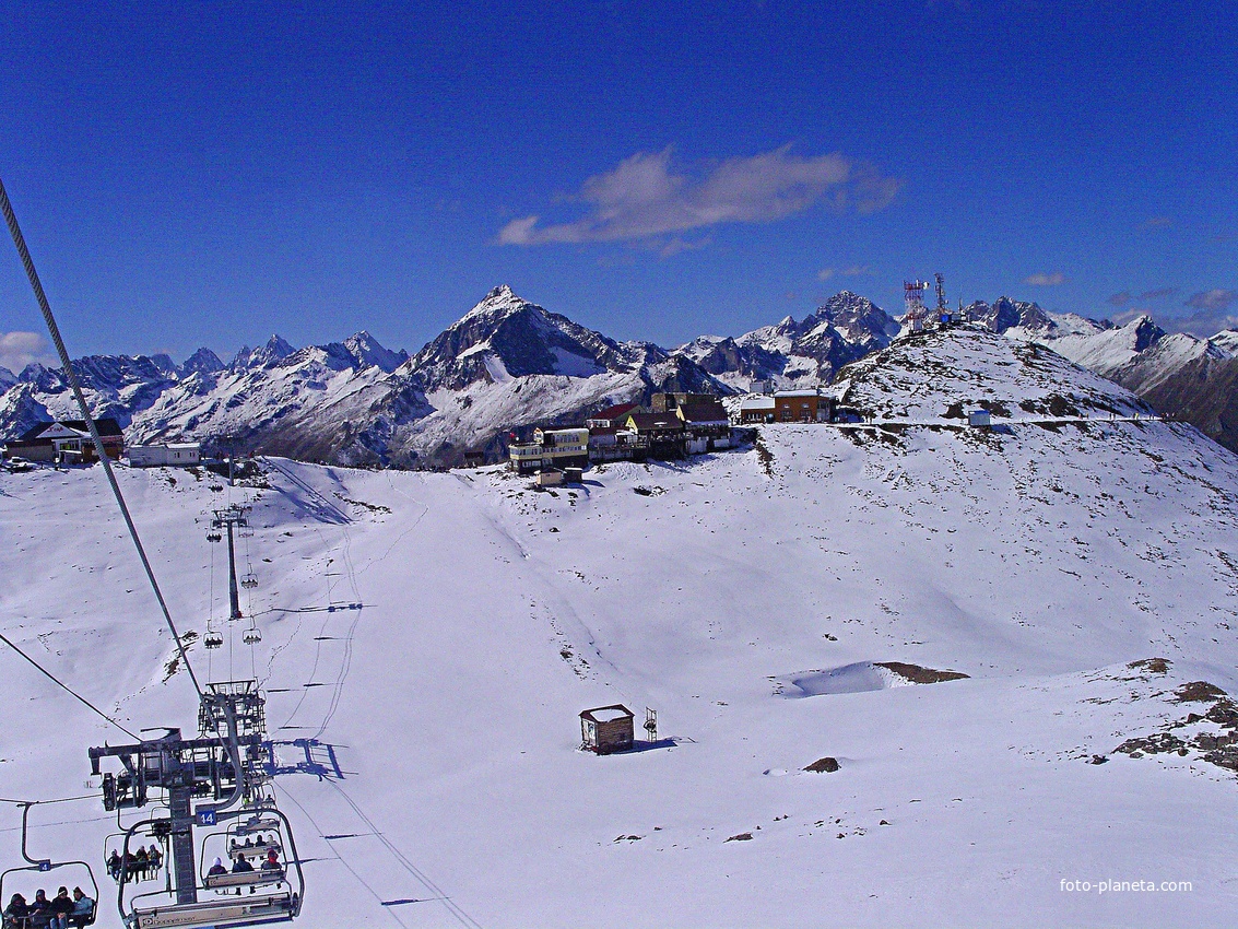 3-я очередь канатной дороги (с новым подъёмником) с открытыми креслами. Внизу станция канатки, отм. 3008м. В центре - пик Семёнов-Баши (3602м)