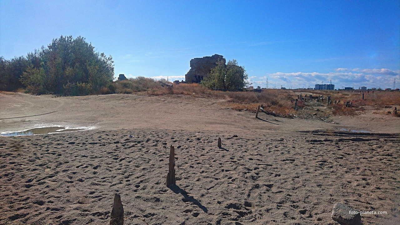 Подсохшая акватория озера Сасык-Сиваш с остатками старых свай и строений. Вдали - застройка села Прибрежного.