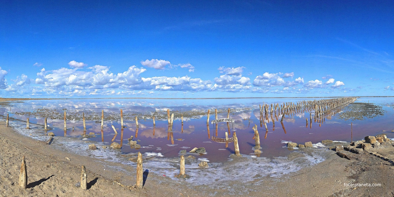 Панорама озера Сасык-Сиваш (Розовое озеро) - самое крупное озеро в Крыму. Цвет озерной воды - из-за бактерий, вырабатываемых водорослями. От их активности вода может менять свой цвет от красного до розового и сиреневого. Соль в озере тоже розовая.