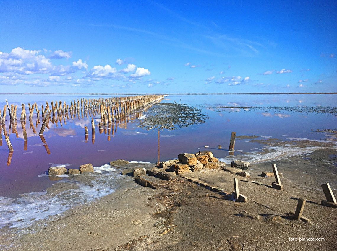Сваи, уходящие в озеро Сасык-Сиваш, — это остатки соледобывающих конструкций. В те времена, когда соль ломали вручную, эти столбы были сваями, на которых лежали деревянные настилы, где сушилась добытая соль.