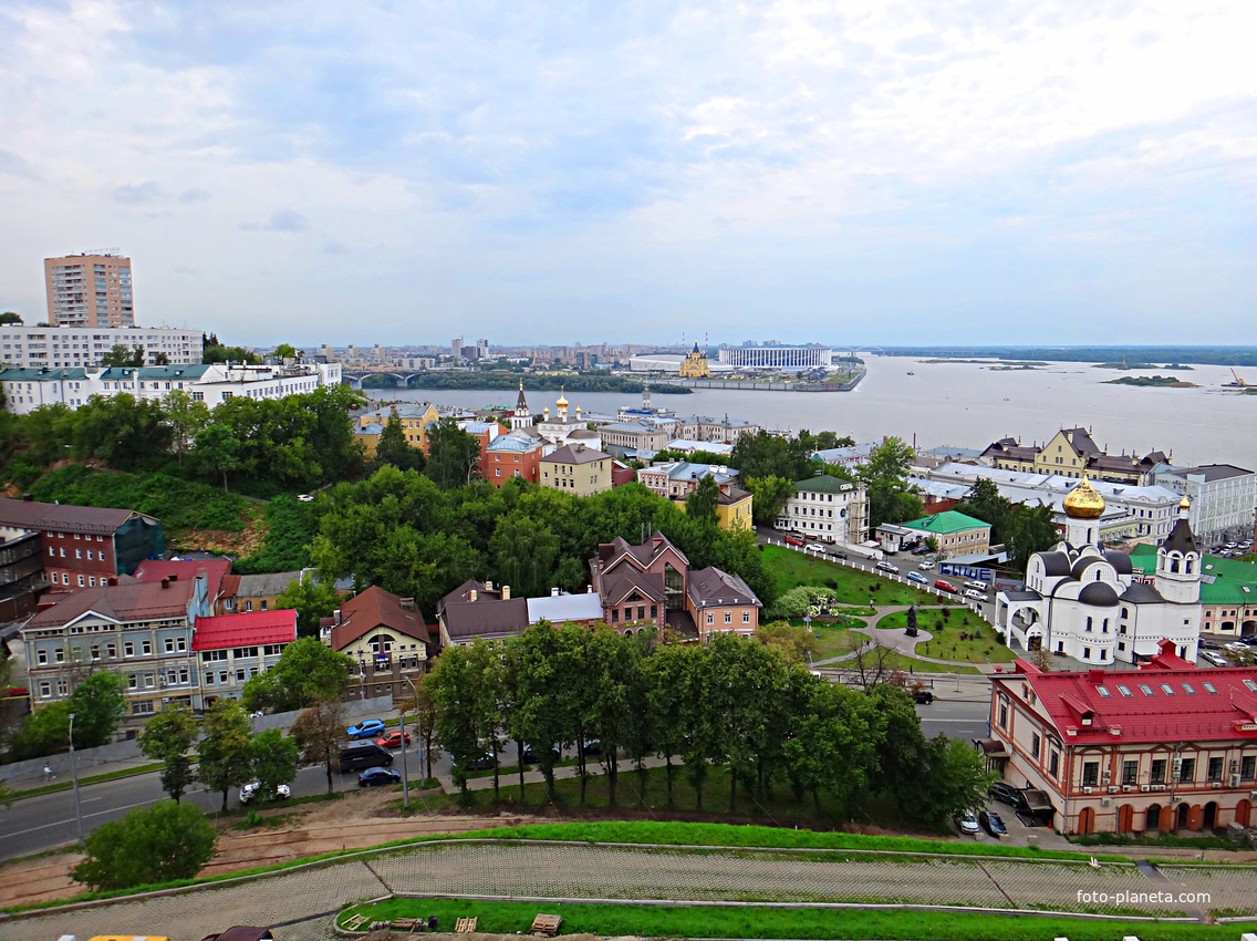 Вид с крепостных стен Кремля у Тайницкой башни на городские постройки. Справа - Казанский храм, перед ним - бывший доходный дом Бугровых, в центре - Ильинский храм, за ним - стрелка Оки и Волги.