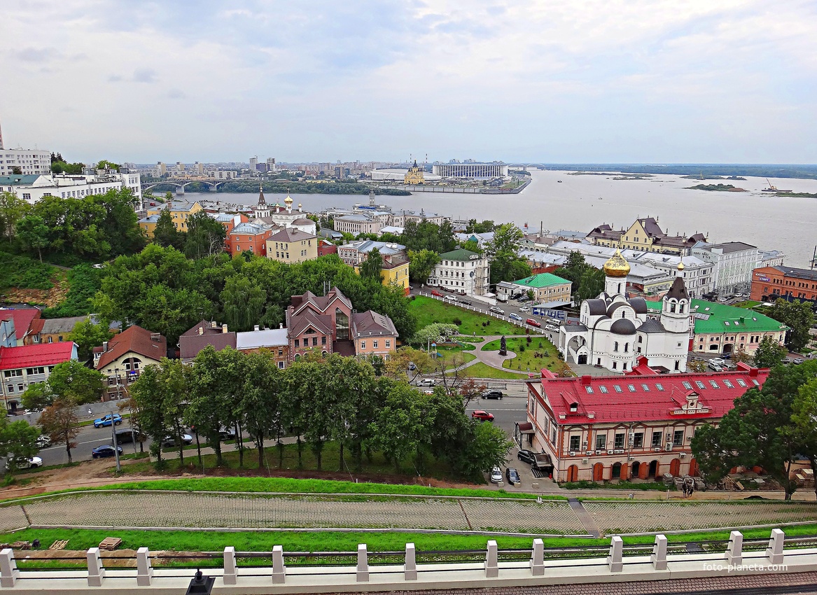Вид с крепостных стен Кремля у Тайницкой башни на городские постройки. Справа - Казанский храм, перед ним - бывший доходный дом Бугровых, в центре - Ильинский храм, за ним - стрелка Оки и Волги.