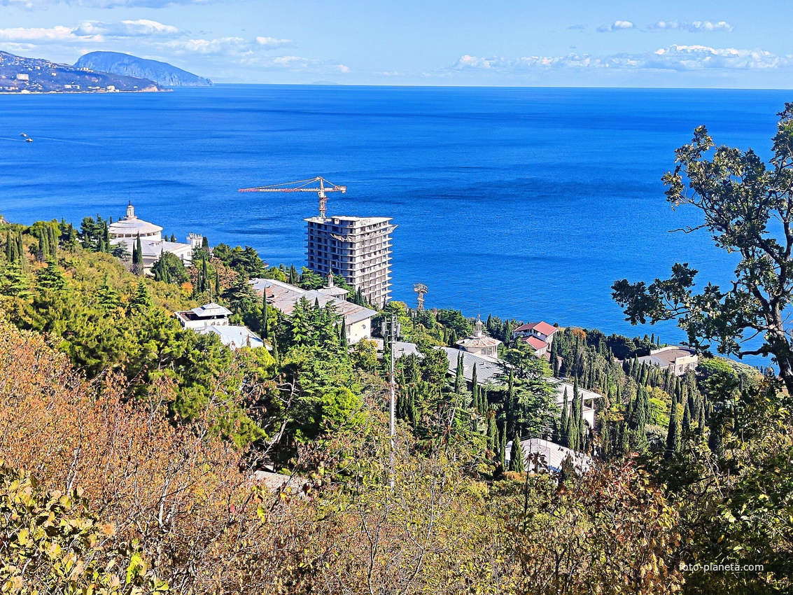 Вид на Черноморское побережье с обрыва возле Царской (солнечной) тропы. Внизу - корпуса санатория "Горный", здание с большой ротондой - клуб со столовой. Непосредственно у берега - строящийся 14-и этажный апарт-комплекс «Царский Берег».