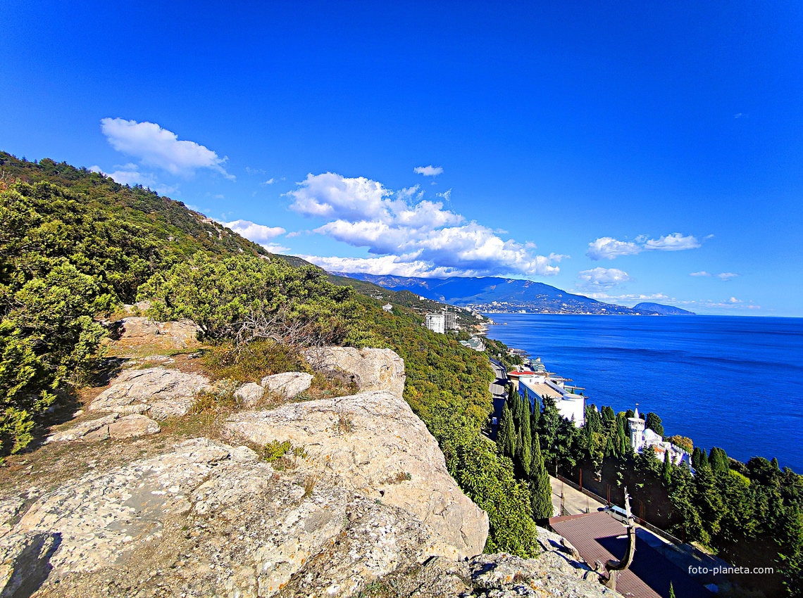 Вид на Черном. побережье с Царской тропы. Дворец Кичкине (летняя резиденция князя Д. К. Романова) на терр. санатория "Кичкине" ФСО РФ в п.г.т. Гаспра.  Далее - строения отеля "Пальмира Палас", ЖК "Южная Пальмира", строящ-ся комплекс «Царский Берег».