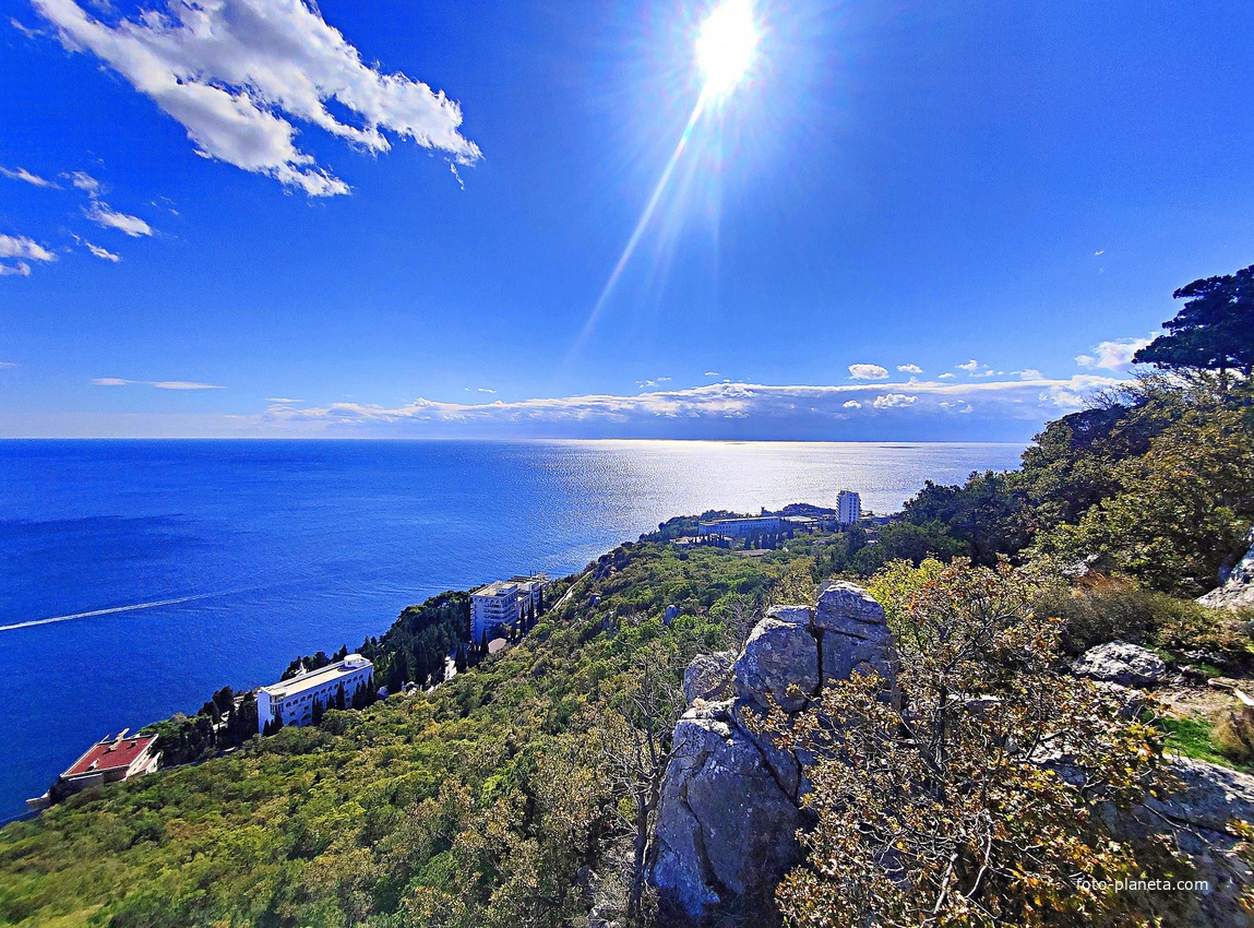 Вид на Черноморское побережье со скалы Утюг. Территория санатория "Кичкине" ФСО РФ (закрытая) в п.г.т. Гаспра, в центре - дворец Кичкине (летняя резиденция князя Д. К. Романова). Справа - жилая застройка посёлка.