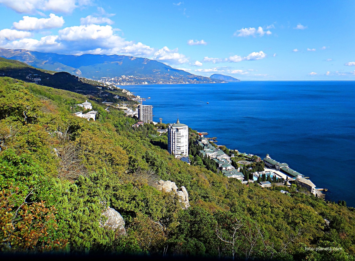 Вид на Черноморское побережье со скалы Утюг. Впереди - строения отеля Пальмира Палас, высотный ЖК "Южная Пальмира", строящийся 14-и этажный апарт-комплекс «Царский Берег»", далее - корпус "Дружба" комплекса «Курпаты» Управ. делами Президента РФ.