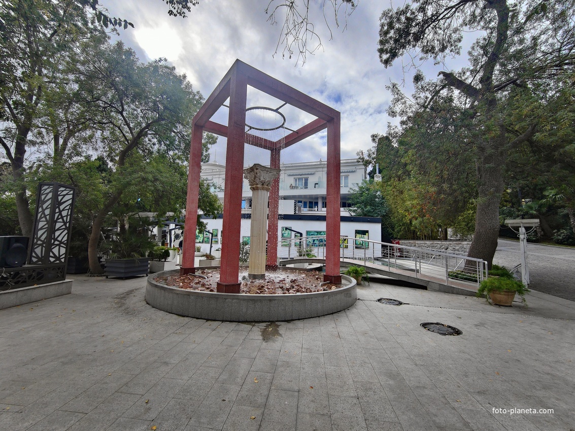 Фонтан с коринфской колонной посередине, вокруг которой ниспадают нити воды в Приморском парке имени Ю. А. Гагарина.