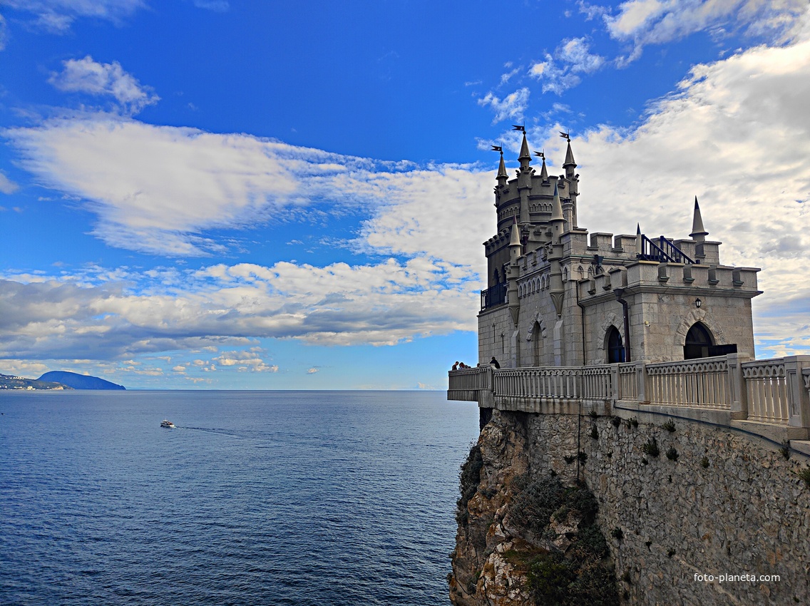 Вид со смотровой площадки во внутреннем дворе замкового комплекса "Ласточкино гнездо" на вершине Аврориной скалы на псевдоготический замок и окружающую акваторию.