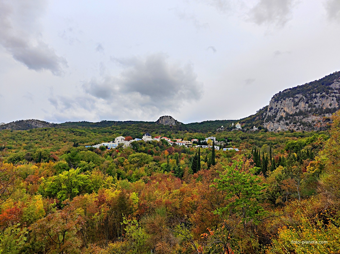Вид с Алупкинского шоссе на посёлок Ореанда. За ним - храмовый комплекс Архистратига Михаила у подножия горы Ай-Никола справа. В центре - гора Урьянда (известная как Ореанда-Исар или Крестовая). Слева - юго-восточный отрог горы Могаби.
