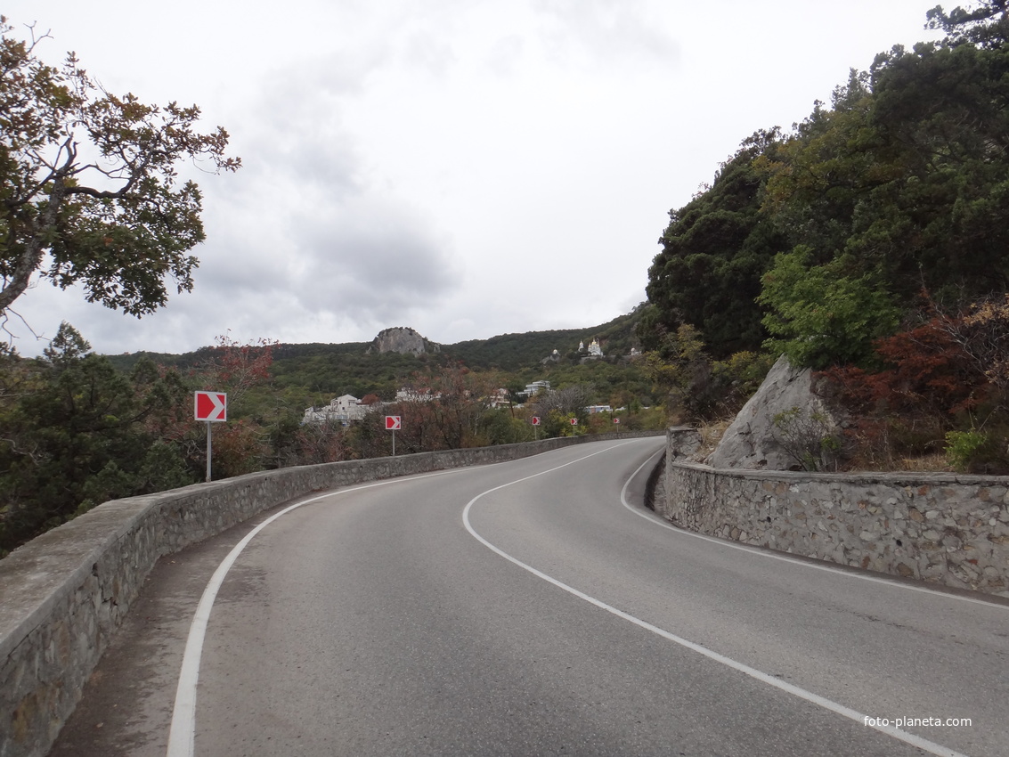 Вид с Алупкинского шоссе на посёлок Ореанда. За ним - храмовый комплекс Архистратига Михаила у подножия горы Ай-Никола справа. Слева - гора Урьянда (известная как Ореанда-Исар или Крестовая).