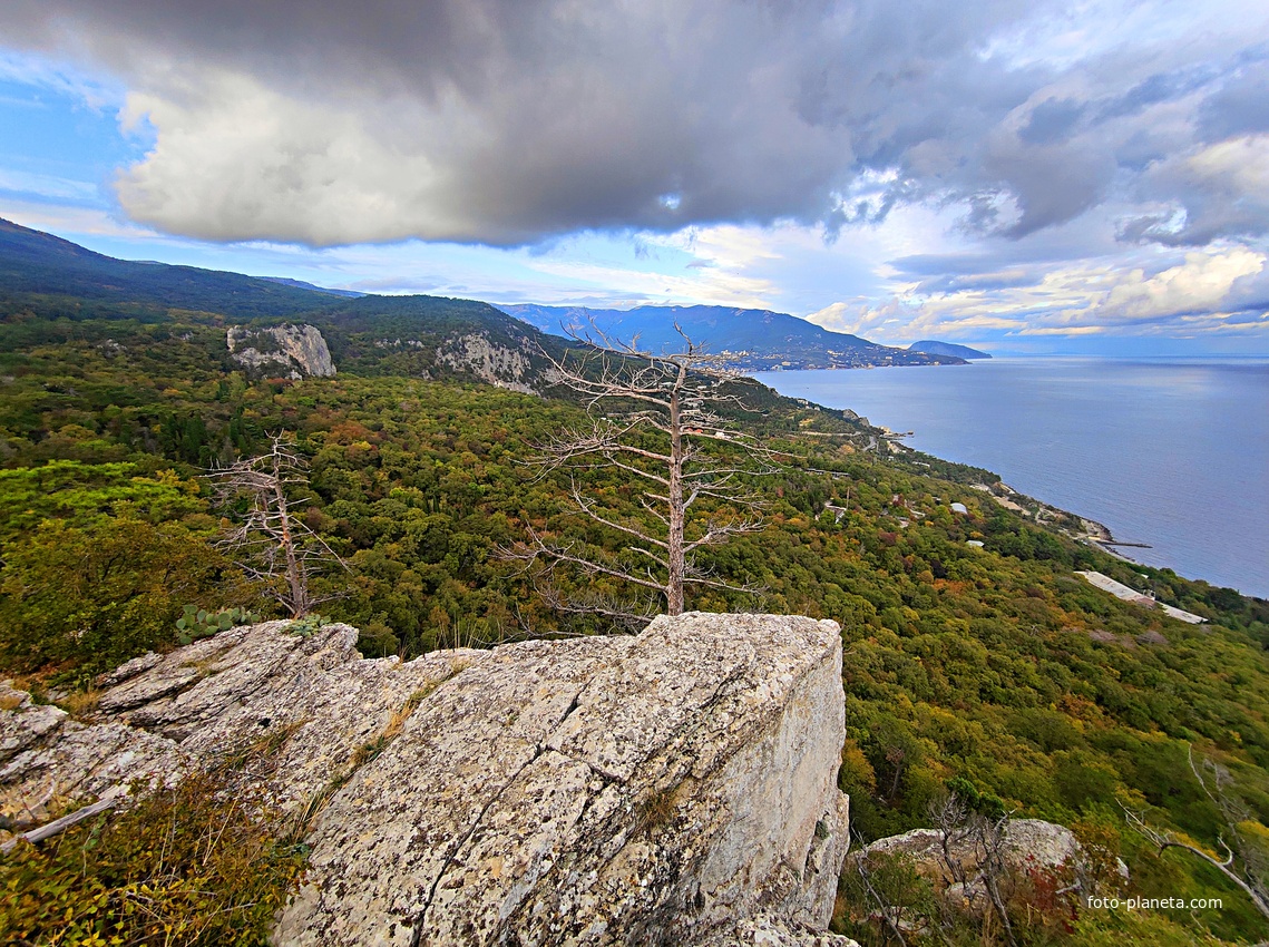 Скальный выступ над одним из обрывов южного склона горного массива Могаби у Стройгородка. Вид на горно-лесистую территорию, побережье к В и С-В от Стройгородка.