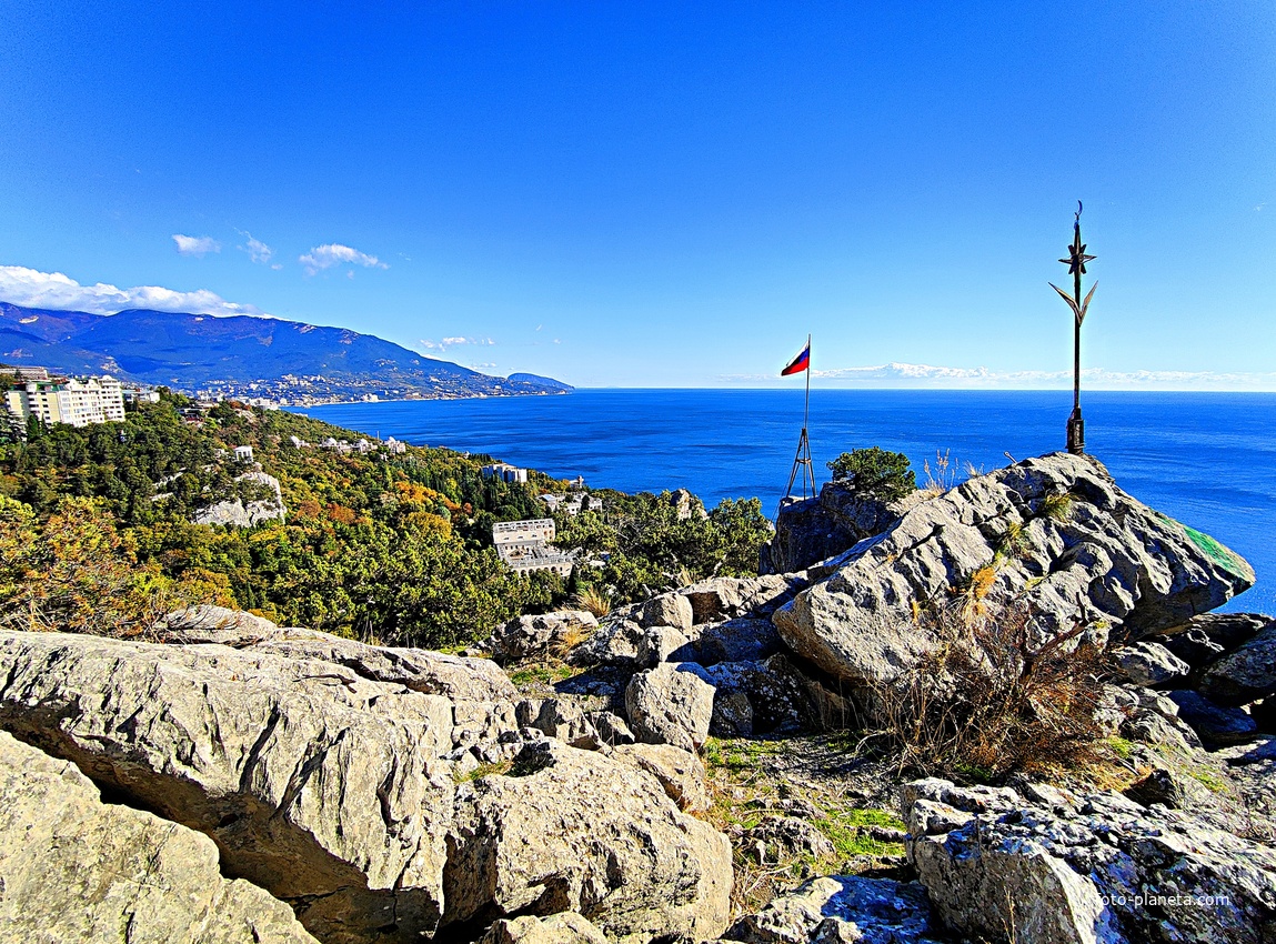 На вершине горы Урьянда (Крестовая). Флаг РФ, установленный в 2014г. И шест с восьмиконечной звездой (Руб аль-хизб) и полумесяцем ( знак «Мира и согласия») - установлен местной крымскотатарской общиной в 2000-х гг..