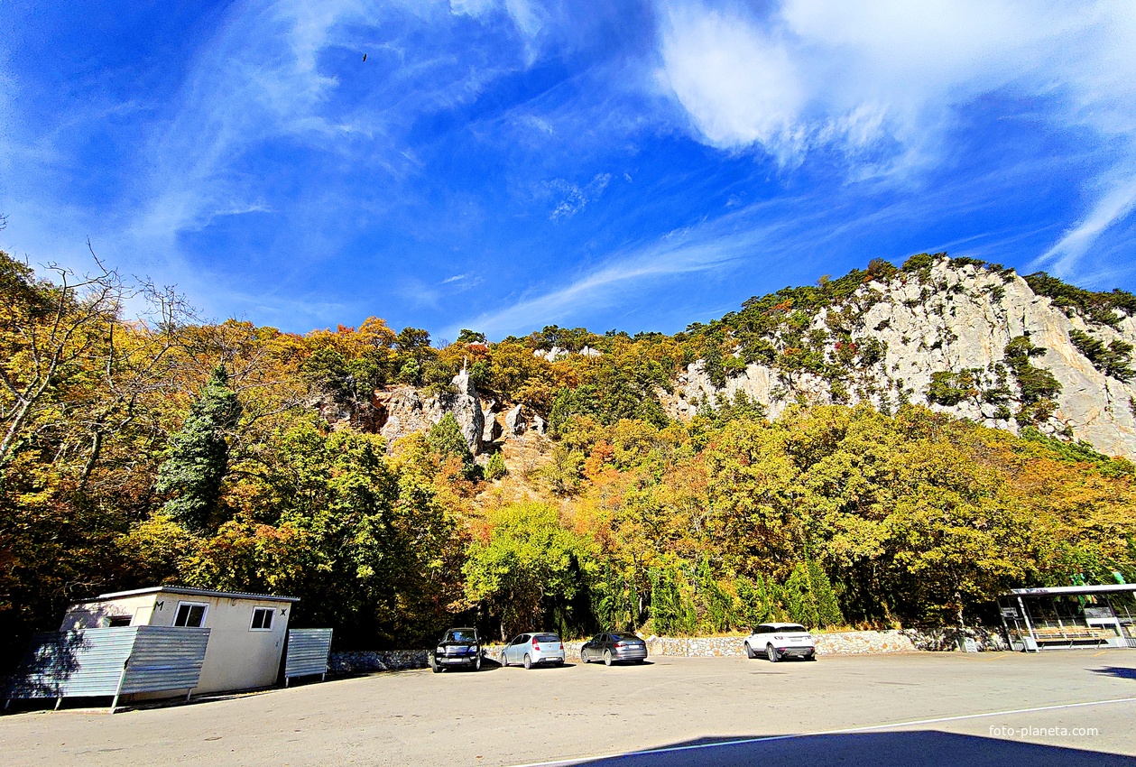 Автостоянка перед храмовым комплексом Архистратига Божия Михаила на Севастопольском шоссе над посёлком Ореанда. Выше - ребро склона горы Ай-Никола с Крестом и Распятием на навершие выступа скалы.