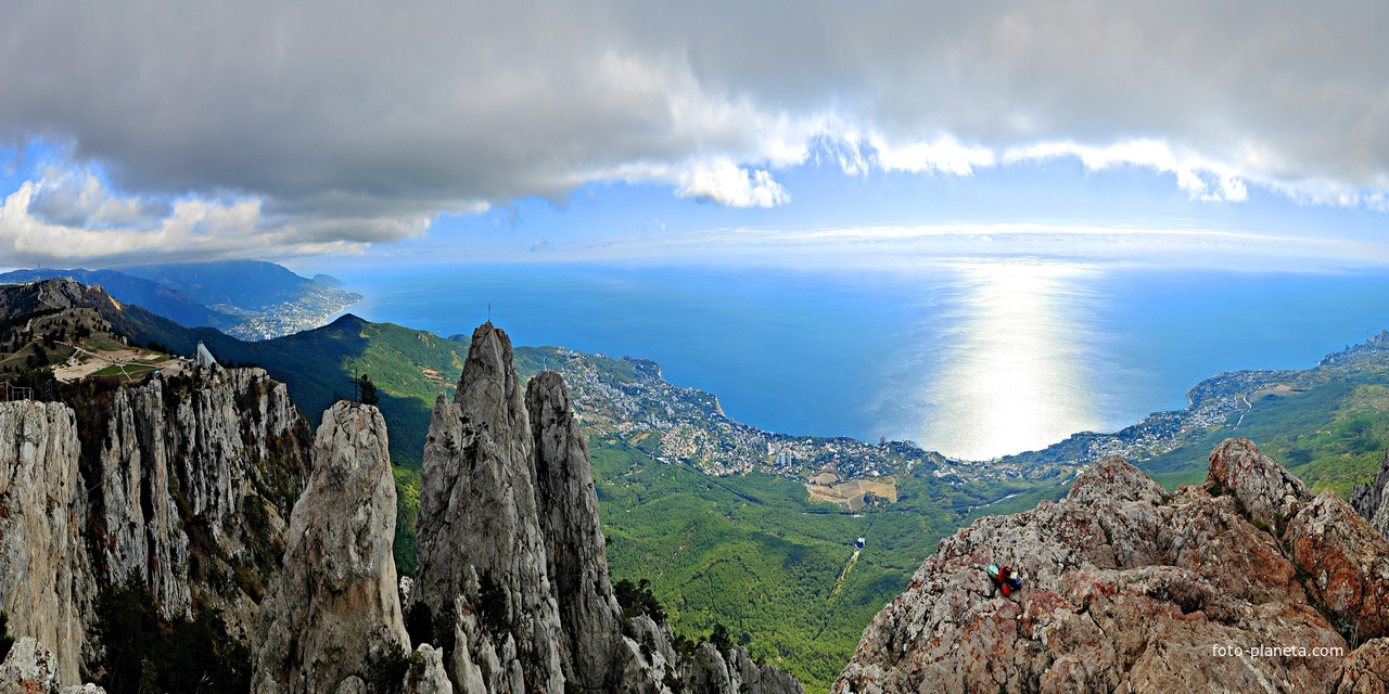 На вершине г. Ай-Петри. Панорамный вид на побережье и чёрном. акваторию. В центре - застройка Кореиза, левее - Гаспры, правее - Алупки и Симеиза. Слева -  зубцы Ай-Петри и плато Ай-Петри, за ними - зелёный конус г. Могаби.