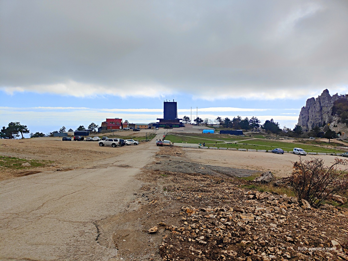 На вершине плато Ай-Петри. В центре - парковка, за ней - верхняя станция канатной дороги, справа - зубцы Ай-Петри.