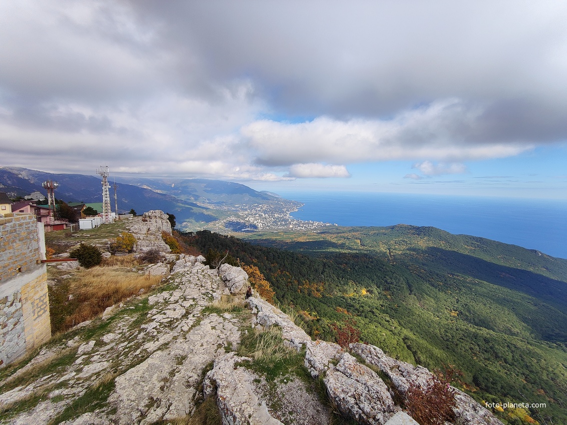 Вид со смотровой площадки скалы Шишко на южный склон Ай-Петринской яйлы. Внизу - черноморская акватория и побережье с застройкой Ялты на южном склоне главной гряды Крымских гор. Слева - вышки сотовой связи.